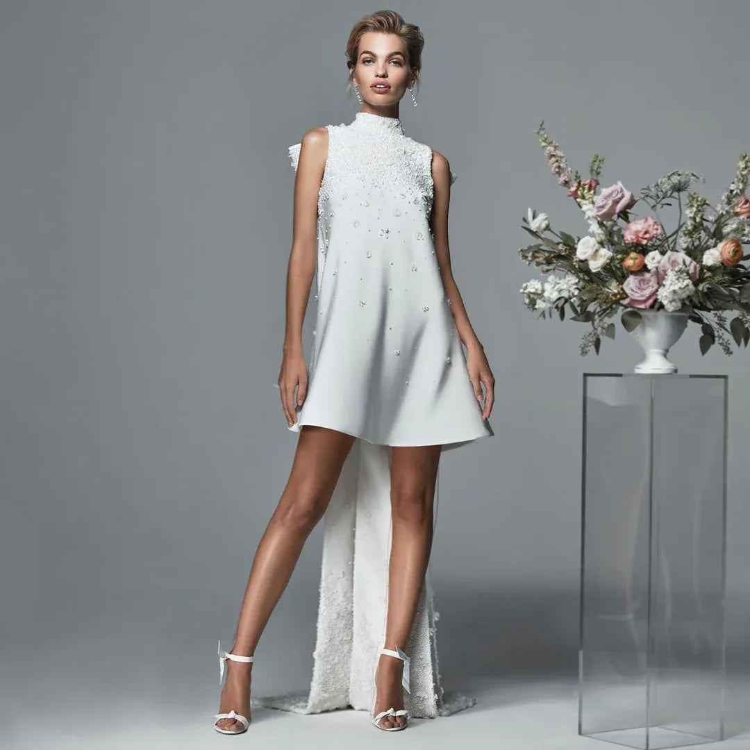 Model wearing a Danarys New York couture bridal weekend mini gown with embellished detailing and a dramatic back train.